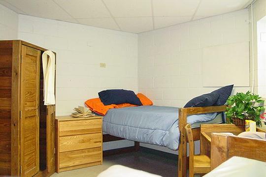基斯顿大学宿舍房间，有床、木厨和大衣橱